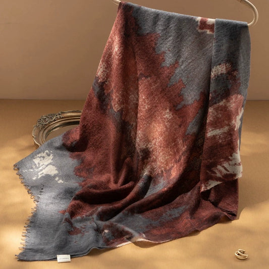 Close-up of the burgundy cashmere scarf, highlighting its intricate abstract design and smooth texture.