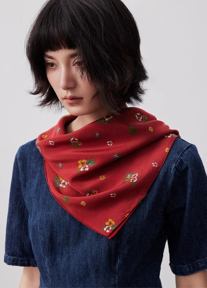 Red floral silk square scarf styled as a neck accessory, demonstrating its elegance and versatility.