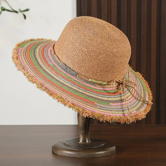 Colorful raffia wide brim sun hat with frayed edge and woven striped brim on hat stand.
