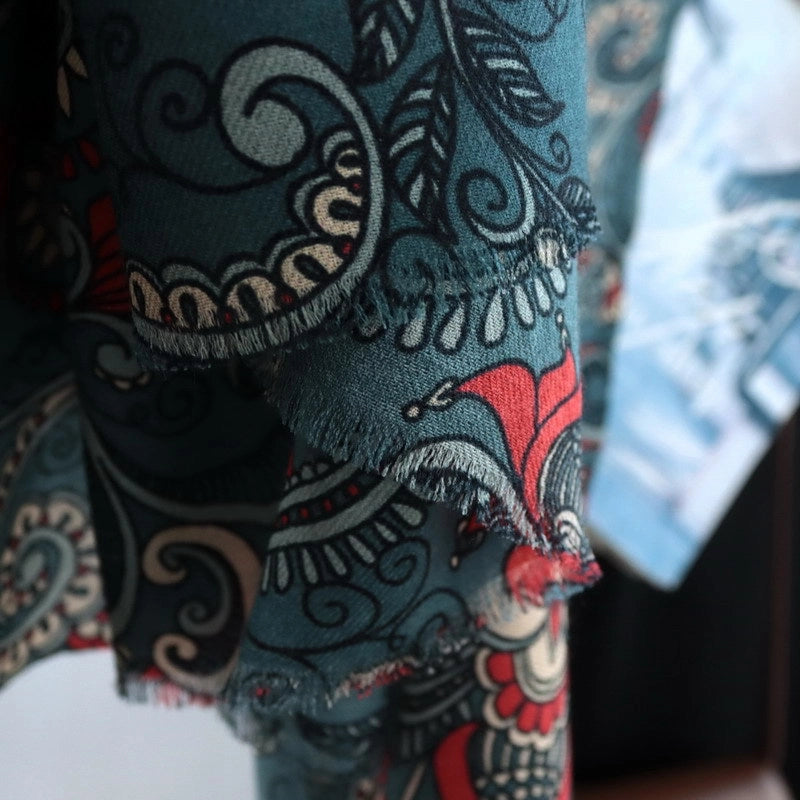 Close-up of the soft draped edge on a dark green vintage paisley floral wool scarf