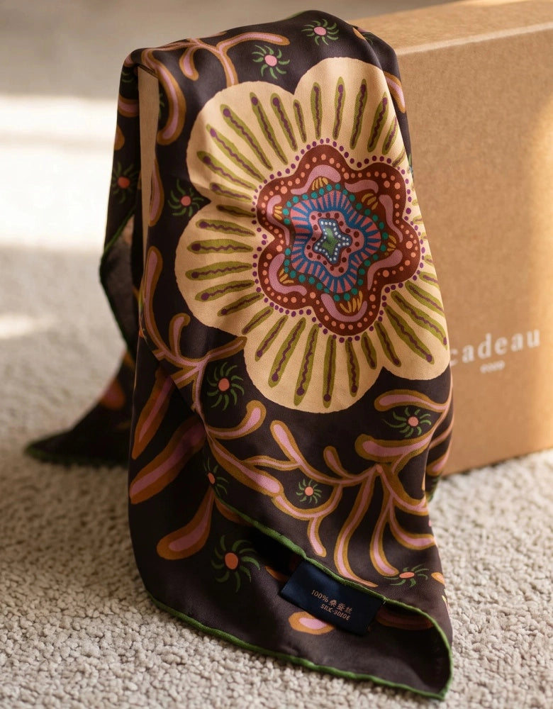 Espresso brown vintage floral mulberry silk scarf softly folded on cream fabric, showing the multicolor print