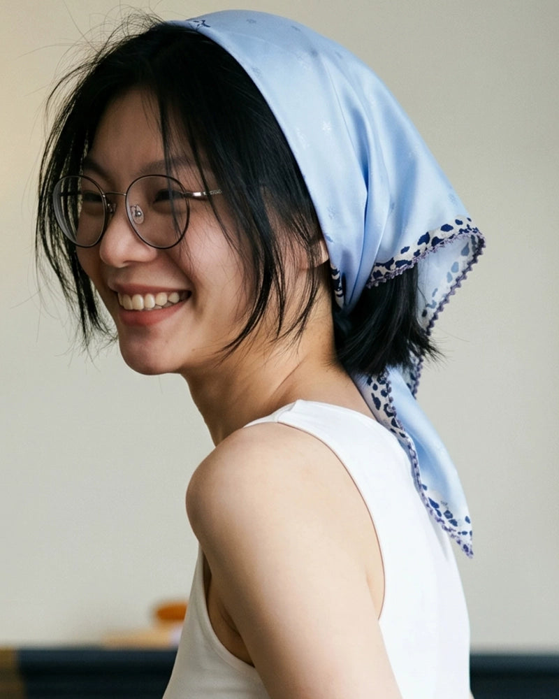 Woman wearing a glacier blue mulberry silk scarf as a headscarf