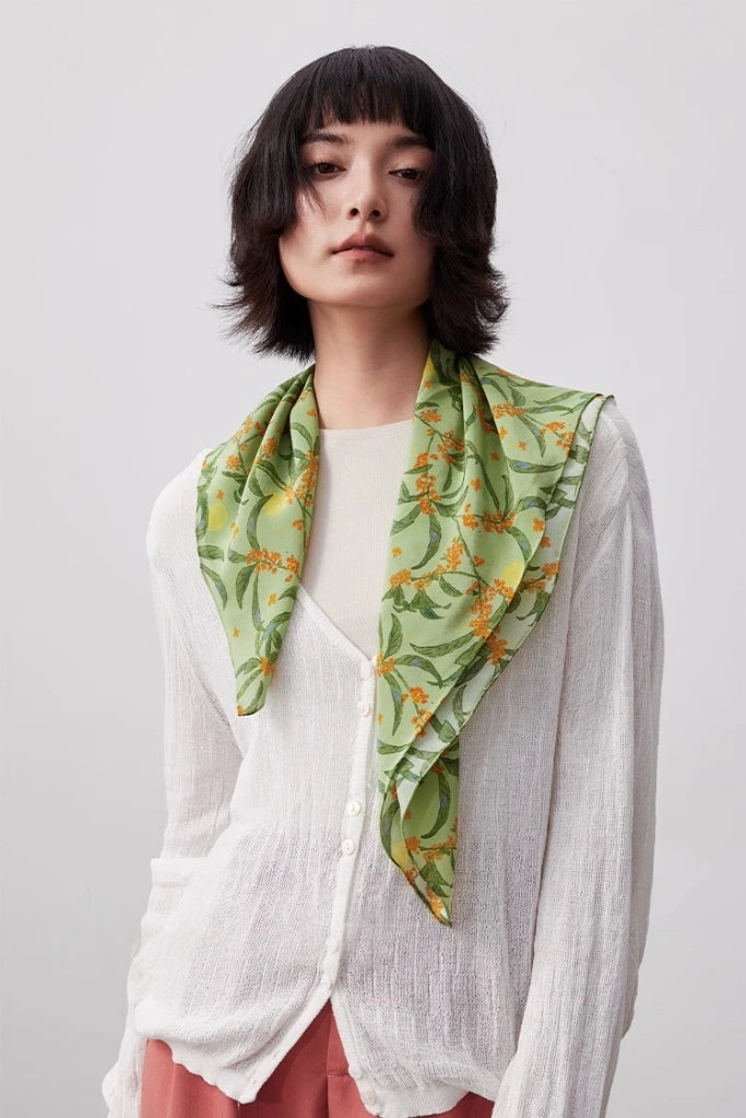 The model wore a green osmanthus silk square scarf as a neck ornament, showing its elegance and versatility from the front.