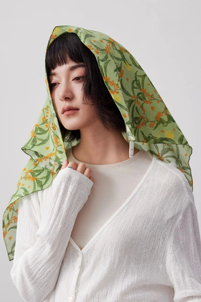 Green osmanthus silk scarf styled as a chic headscarf, showcasing its lightweight and breathable material.