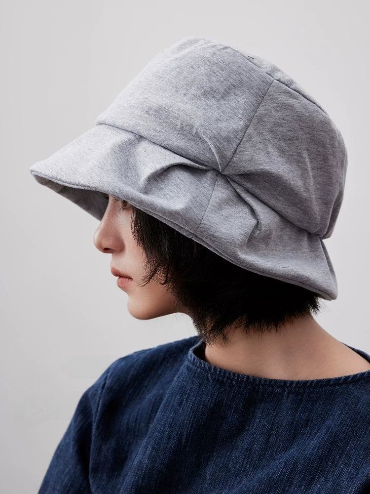 Side view of a heather gray pleated bucket hat with sculpted folds and a curved sun-shading brim