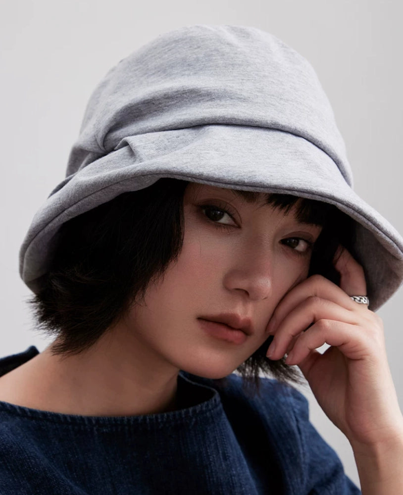 Front close-up of a heather gray pleated bucket hat with a softly wrinkled brim on a model