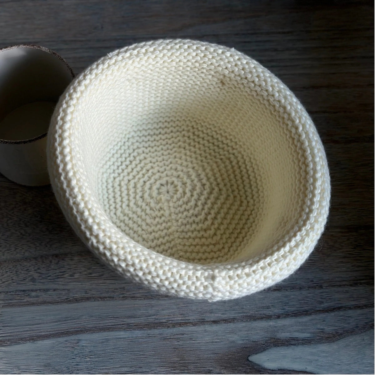 Interior view of an ivory wool blend knit beanie showing spiral construction and a rolled brim