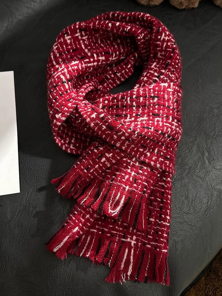 New Year red cashmere tweed scarf looped on a dark chair, showing white woven checks and fringed ends.