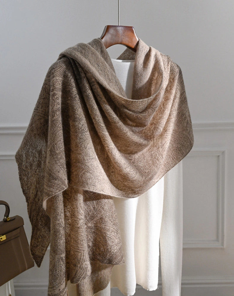 Plum brown cashmere shawl styled over a white top, with an asymmetrical drape and long hanging ends.