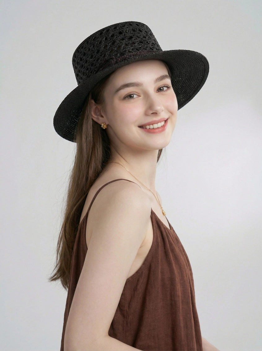 Side view of black raffia boater hat styled with summer dress on model.