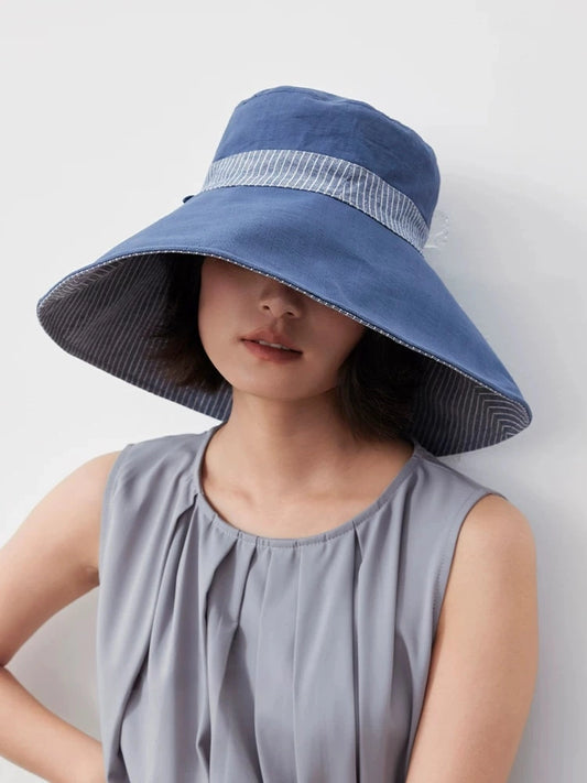 Model wearing a smoky blue reversible wide brim cotton linen sun hat