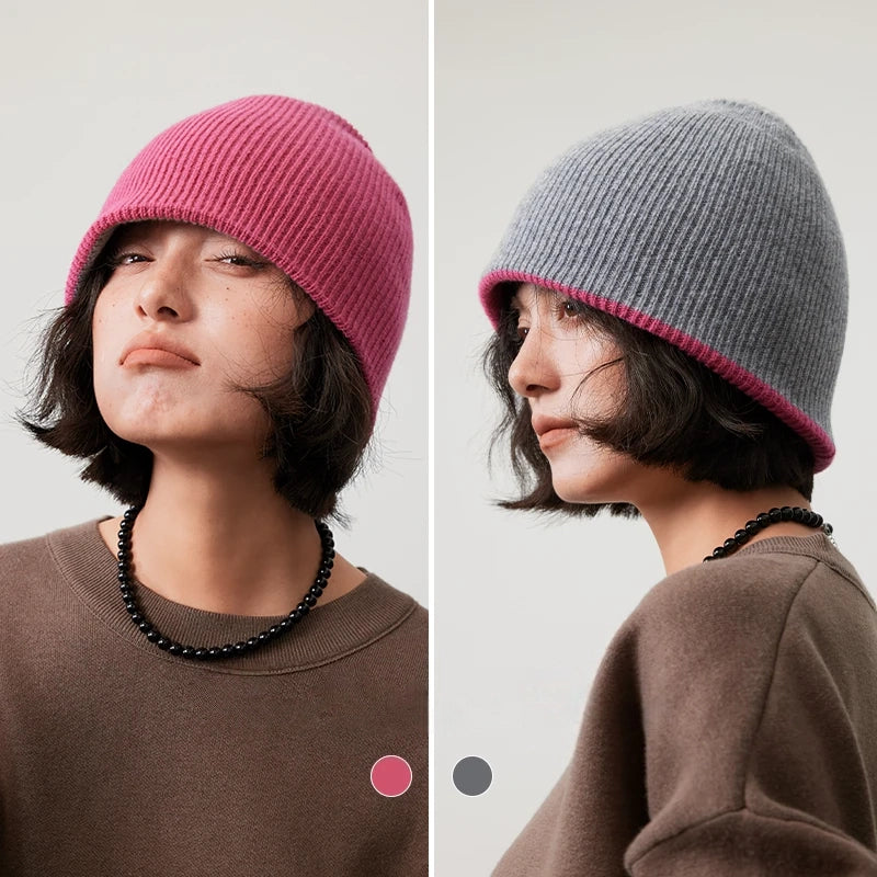 Rose pink and light gray reversible wool beanie modeled with each side facing outward.