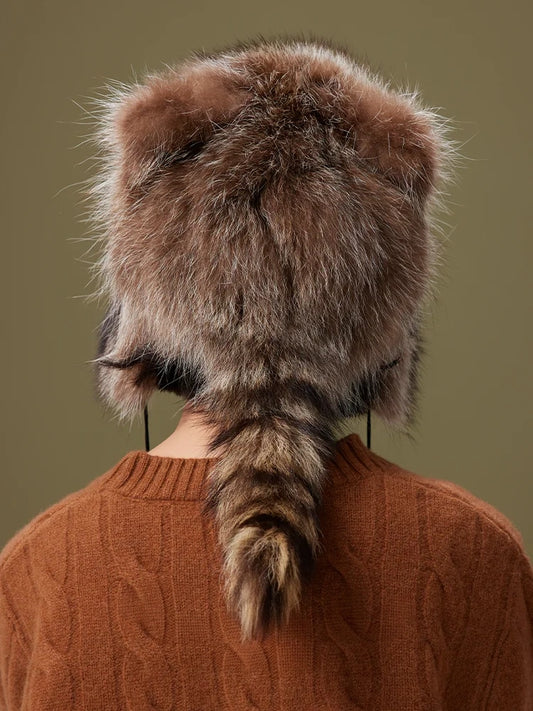 Rear view of a brown-grey fur trapper hat with a rounded crown and a ringed tail hanging down the back.