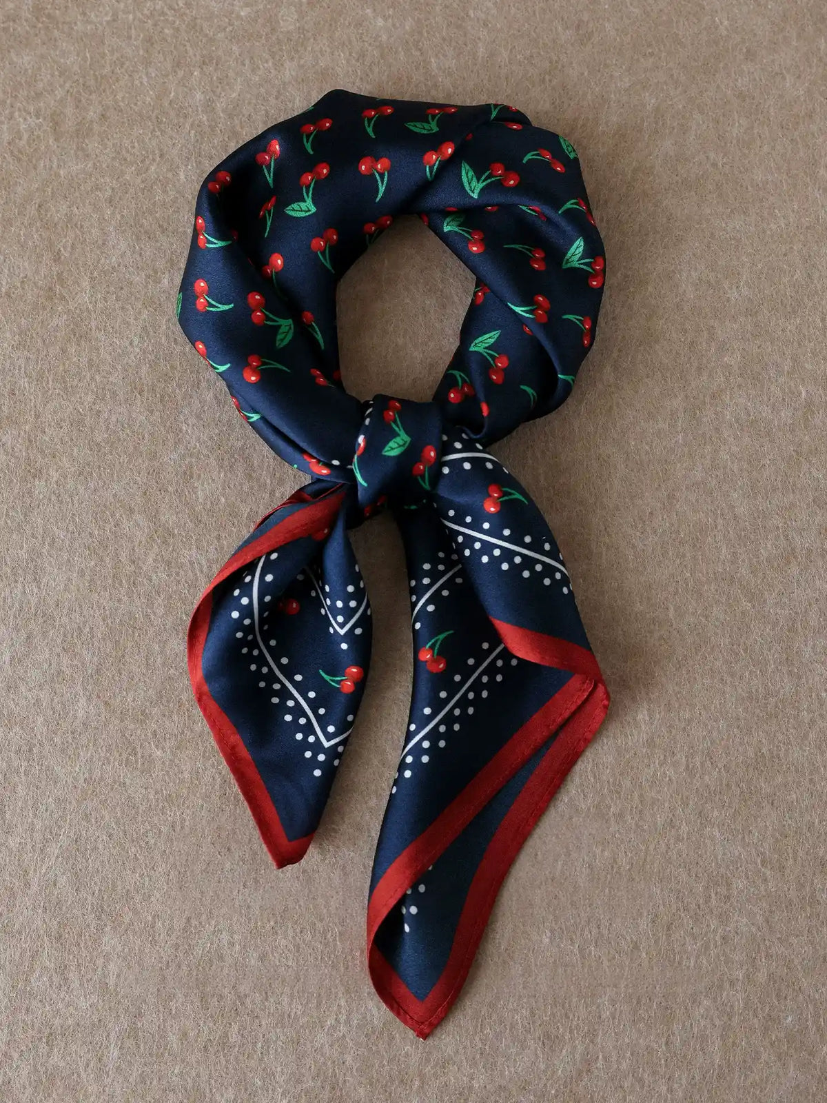 Vintage navy cherry silk square scarf tied in a neat knot with contrasting red trim