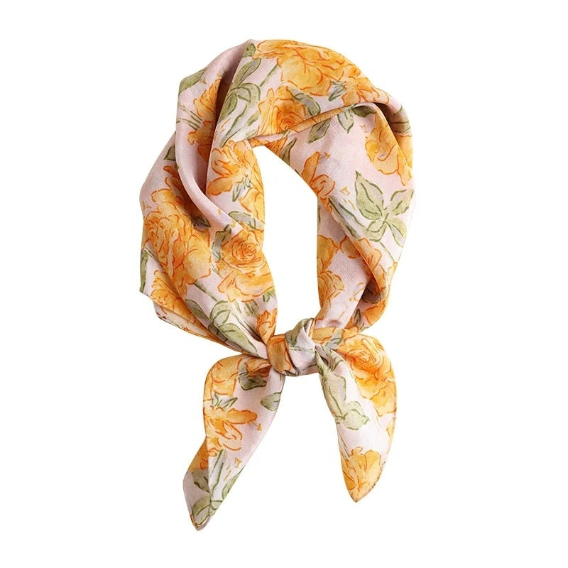 Close-up of a yellow rose print silk square scarf, highlighting the intricate floral pattern and luxurious mulberry silk material.