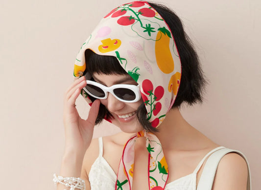 Woman wearing colorful fruit print silk scarf headscarf with sunglasses, elegant summer fashion styling