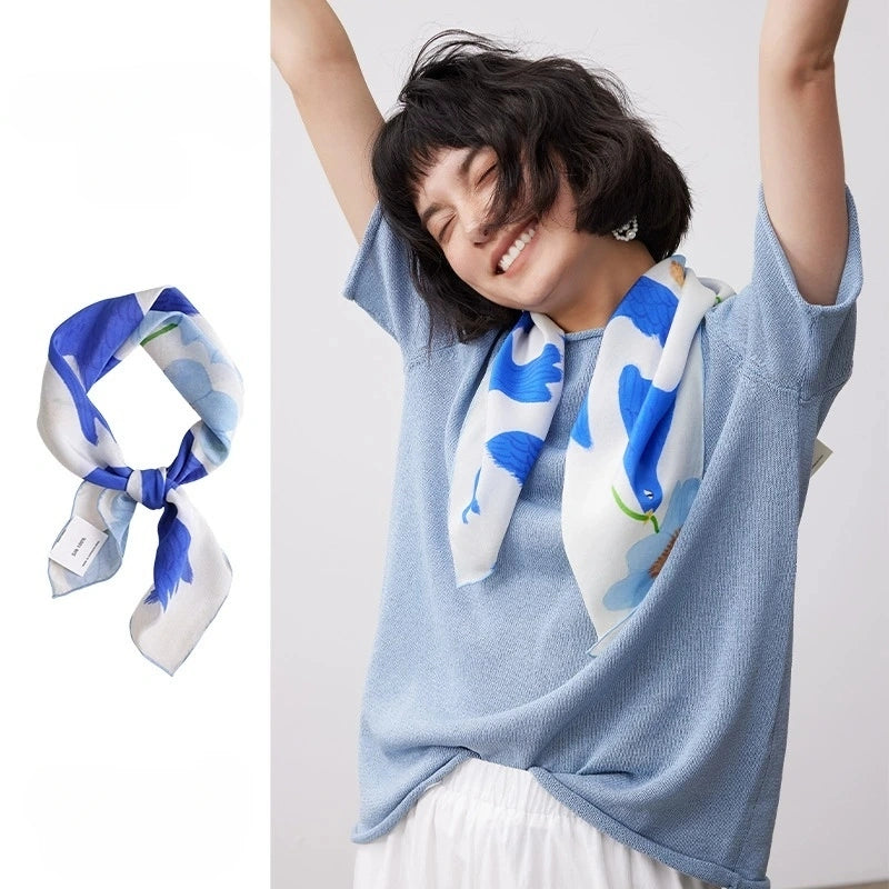 Blue bird flower silk square scarf styled around the neck with matching flat lay detail