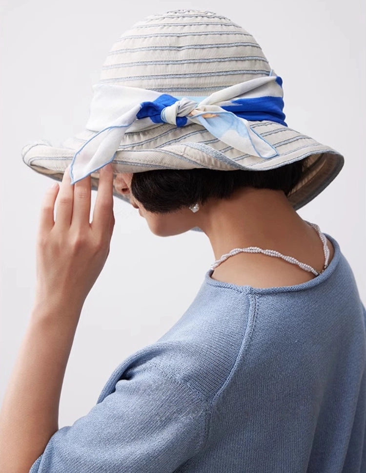 Blue bird flower silk scarf tied around a summer hat for vacation styling
