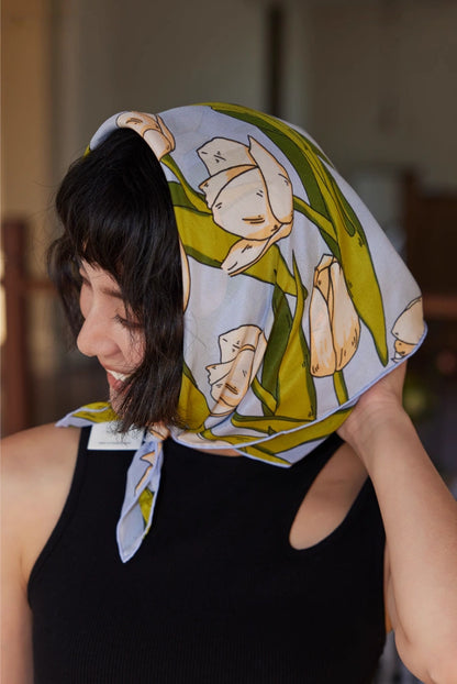 A blue tulip floral print silk square scarf made from 100% mulberry silk, shown as a close-up headscarf.