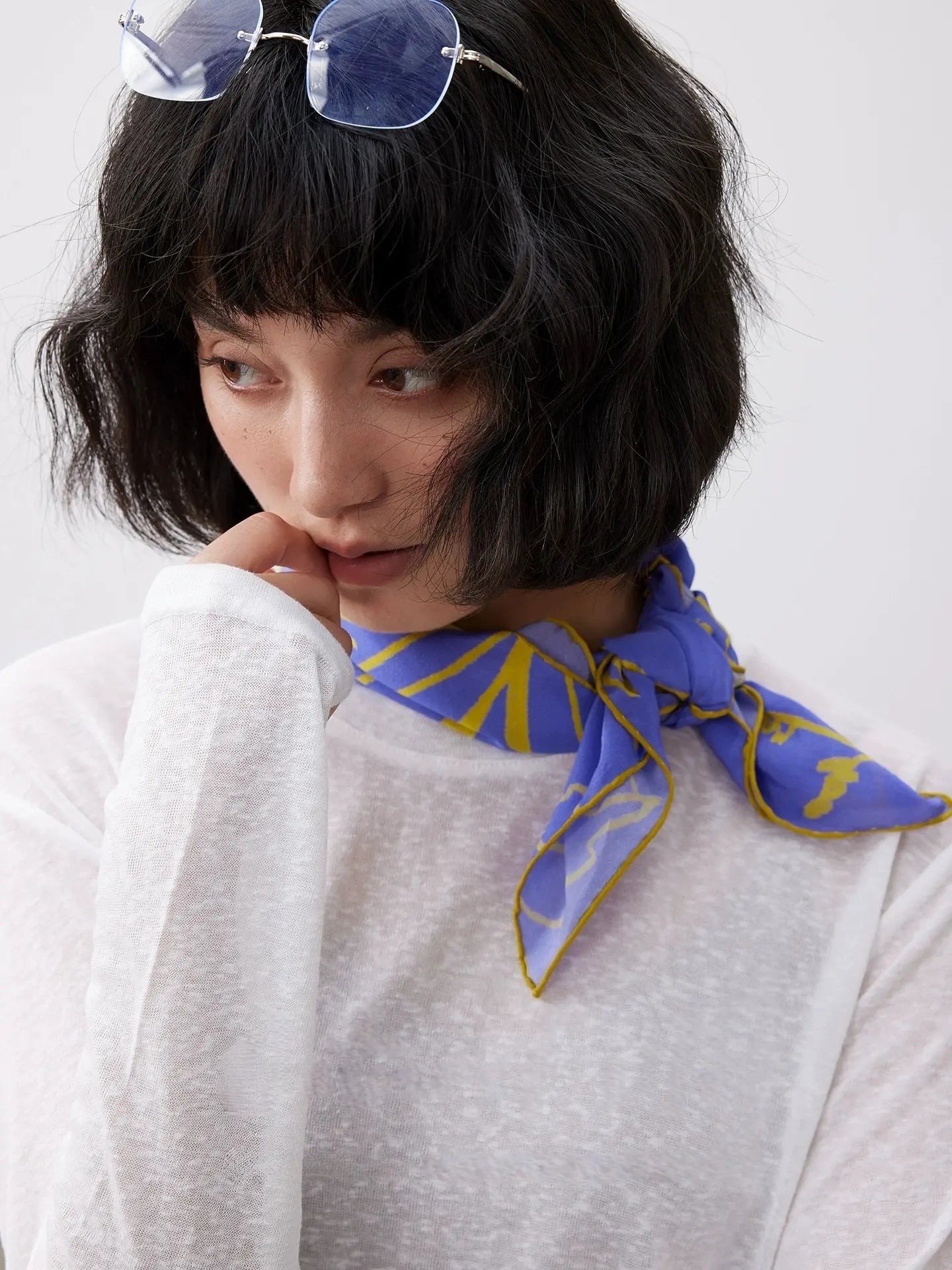 Close-up of blue botanical silk scarf tied neatly around the neck