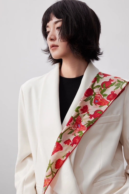 Blush pink mulberry silk triangle scarf worn as a shoulder accent over a white blazer
