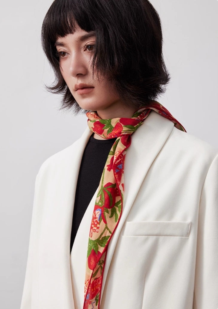 Blush pink triangle silk scarf tied as a neck scarf with a white blazer