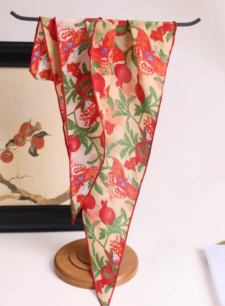 Blush pink pomegranate butterfly silk scarf displayed on a hanger