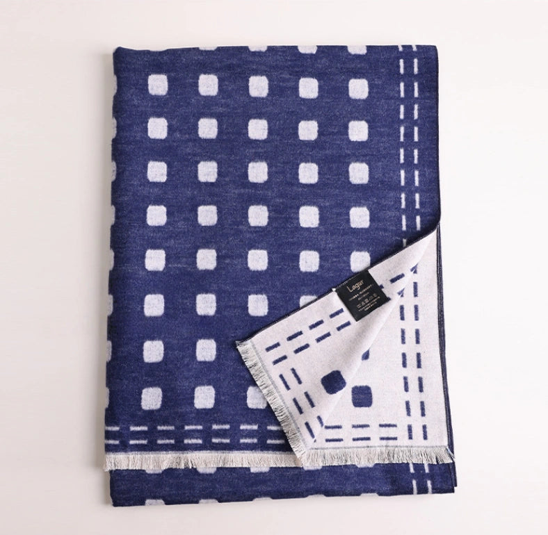 Folded navy blue and ivory brushed silk scarf showing geometric dot pattern and soft fringed edges