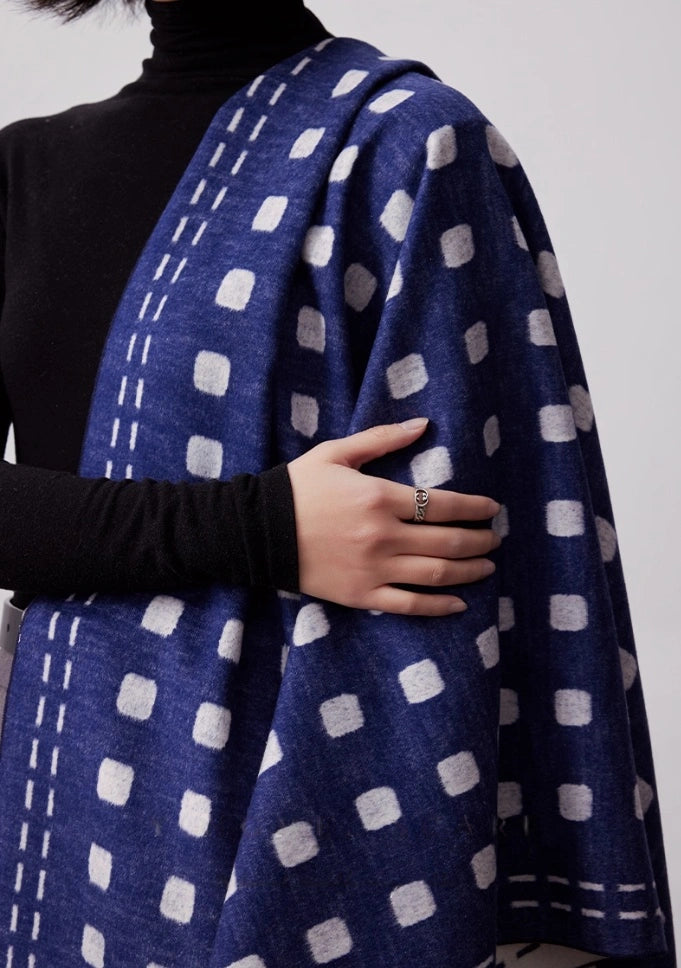 Close-up of navy blue large brushed silk scarf with ivory geometric dot pattern and soft fringed edge