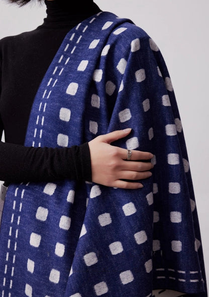 Close-up of navy blue large brushed silk scarf with ivory geometric dot pattern and soft fringed edge