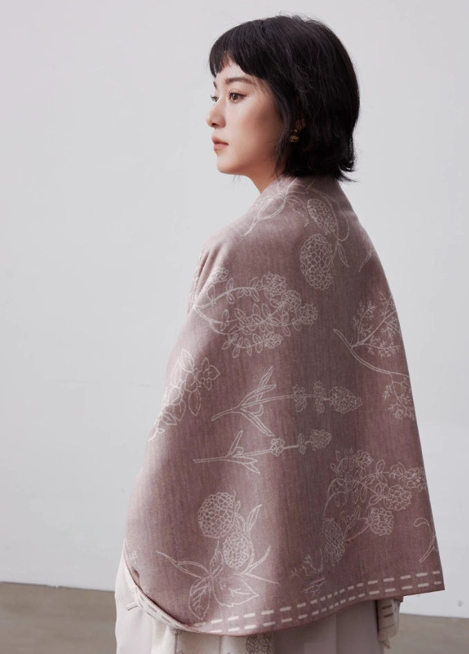 Pale pink large brushed silk scarf worn as a soft shoulder wrap with elegant white floral line art print