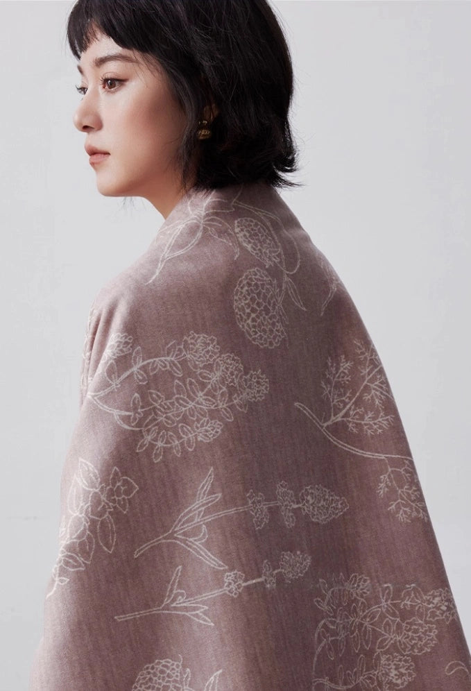 Close-up of pale pink mulberry silk scarf with brushed texture and delicate botanical pattern