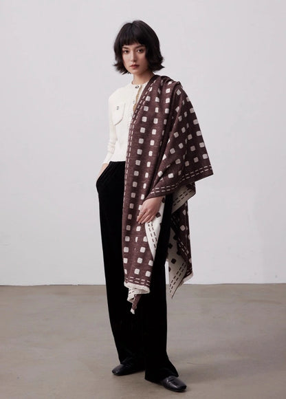 Model wearing a brown brushed silk wrap as an oversized shawl with elegant geometric dot pattern