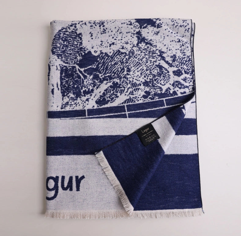 Folded navy blue brushed silk scarf with artistic abstract print, soft fringed edge, and mulberry silk texture