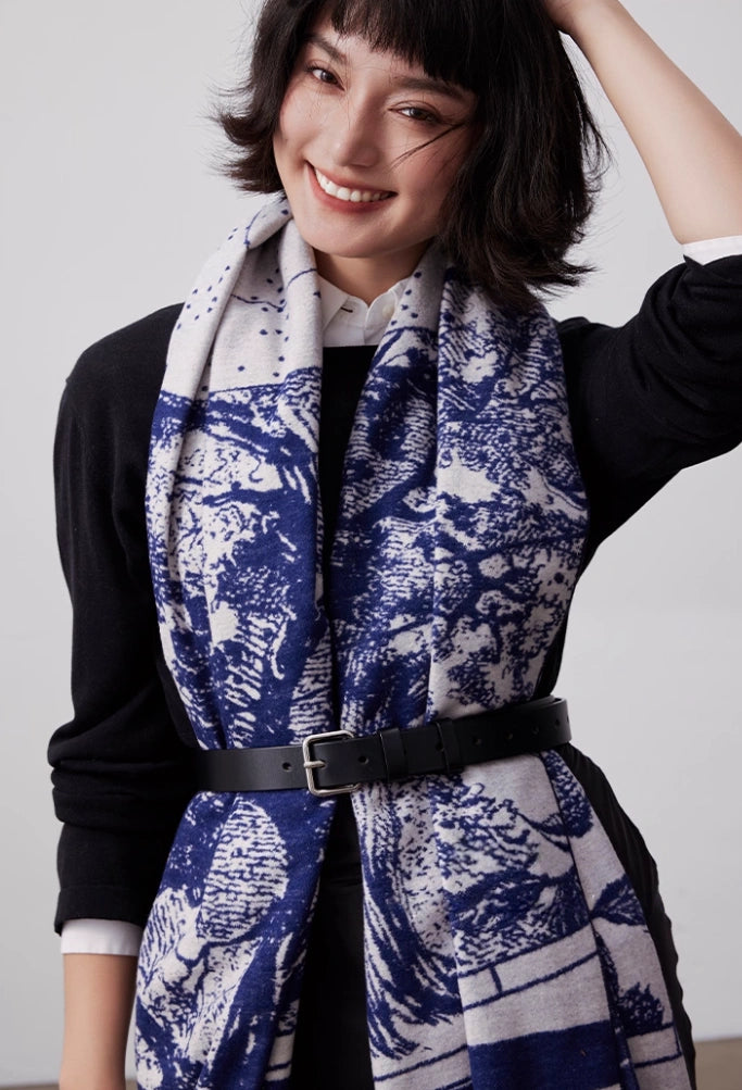 Model wearing a large brushed silk scarf in blue and ivory, belted for elegant layered styling