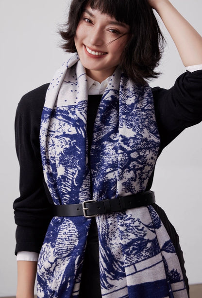 Model wearing a large brushed silk scarf in blue and ivory, belted for elegant layered styling