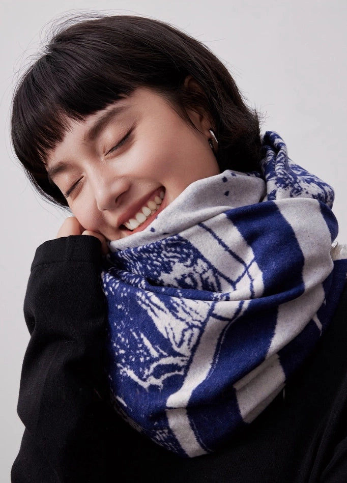 Close-up of a blue brushed silk scarf wrapped around the neck with soft cashmere-like texture