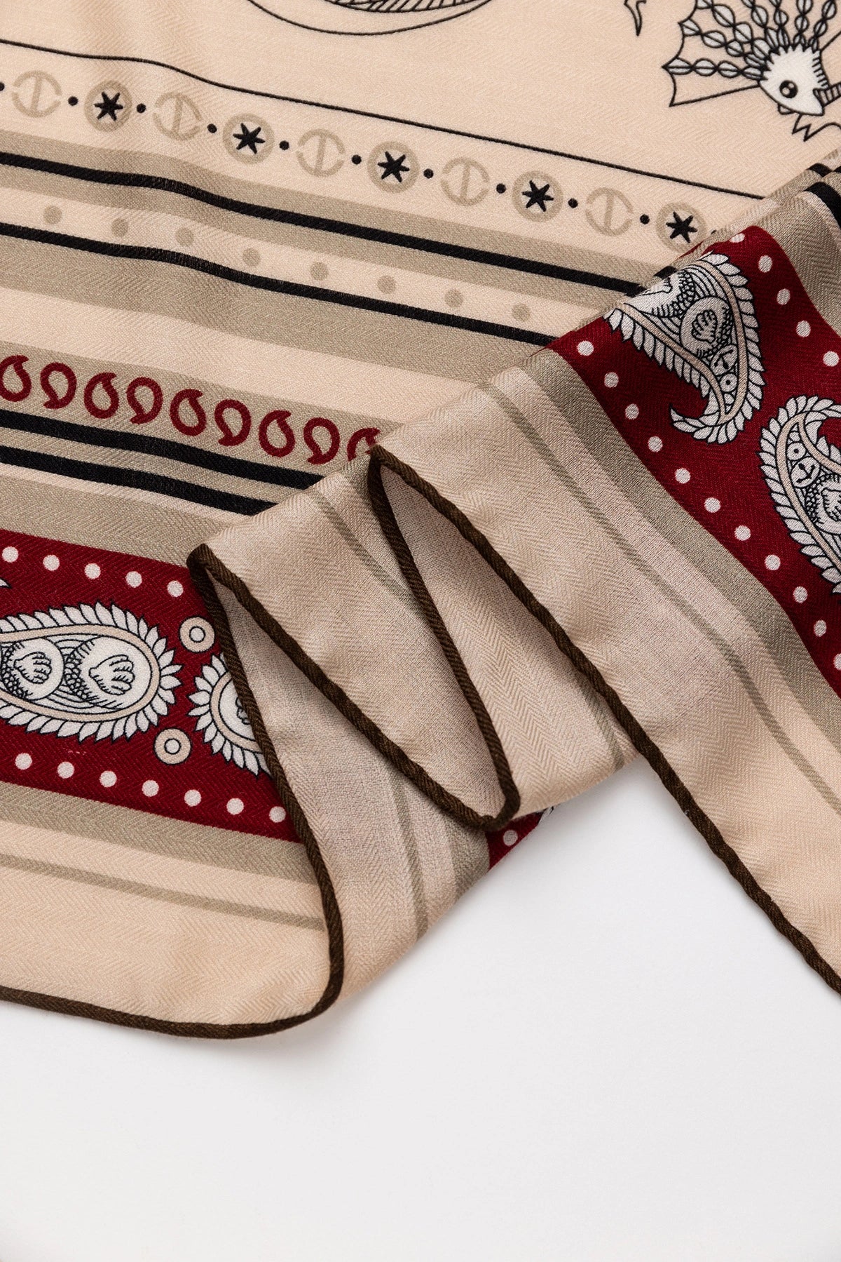 Close-up of Silk Wool Square Scarf - Nautical Fantasy Print | Burgundy,highlighting red paisley edge and beige fabric.