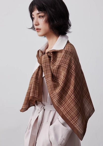 Coffee plaid silk scarf draped over the shoulders with a classic white outfit