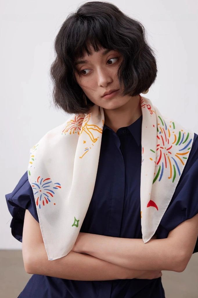 White fireworks ballerina silk square scarf draped over the shoulders with a navy outfit