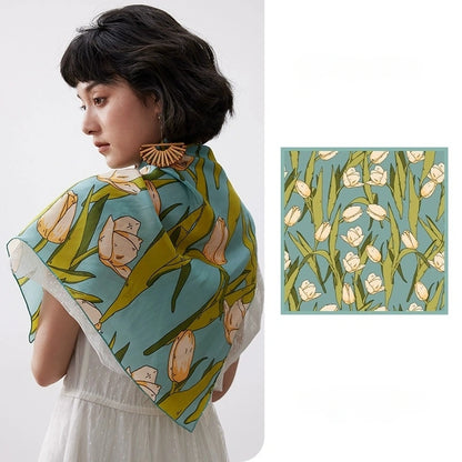 Green tulip floral mulberry silk square scarf styled over a white dress with matching flat lay detail