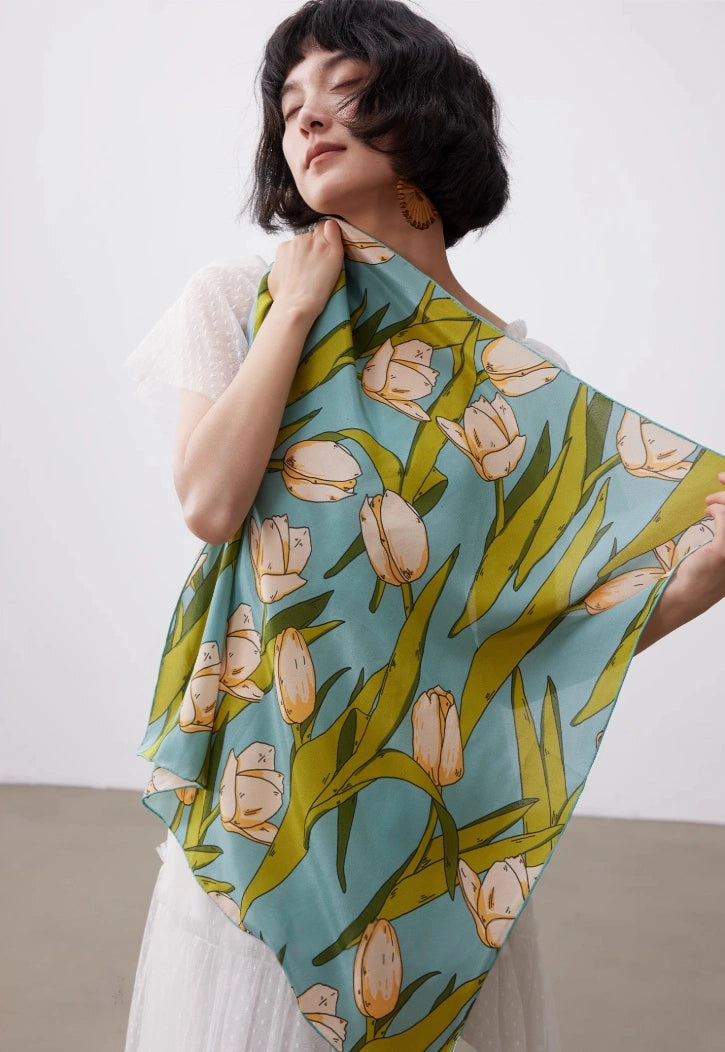 Green tulip print silk square scarf styled as a soft silk shawl