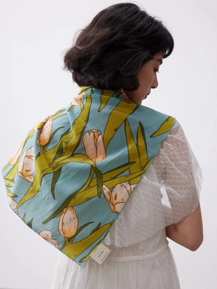 Green tulip mulberry silk square scarf styled over a white blouse