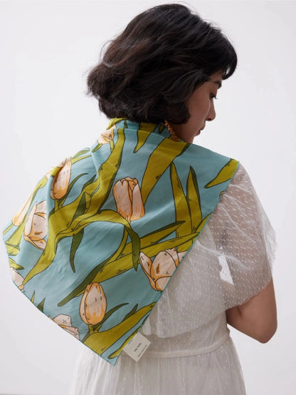 Green tulip mulberry silk square scarf styled over a white blouse