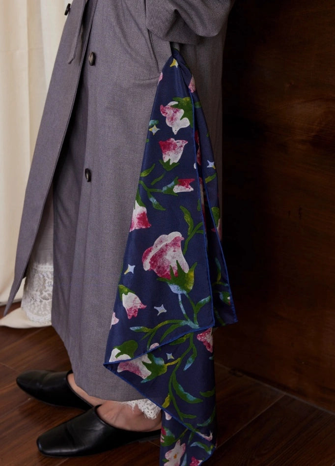 Midnight Blue silk square scarf draped gracefully, emphasizing its smooth texture and chic floral design.