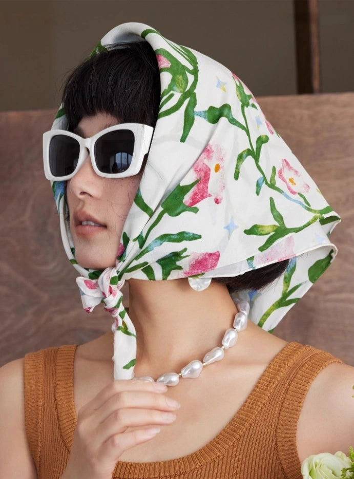 Moonlight White silk square scarf worn as a headscarf, accentuating its delicate morning glory pattern and luxurious feel.