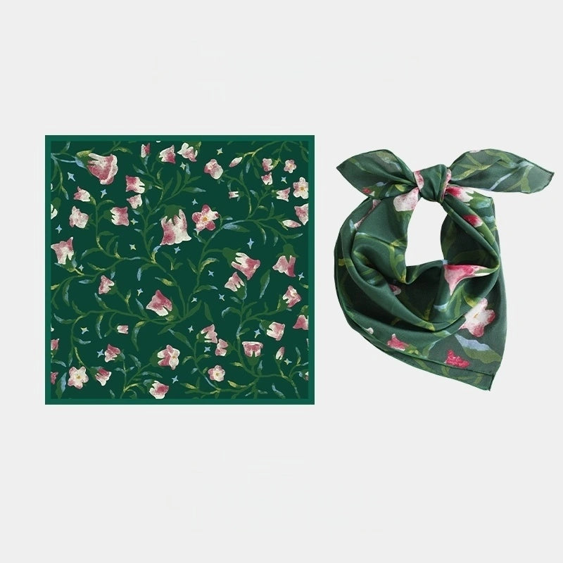Close-up of Wilderness Green silk scarf, showcasing the delicate morning glory floral pattern and luxurious texture.