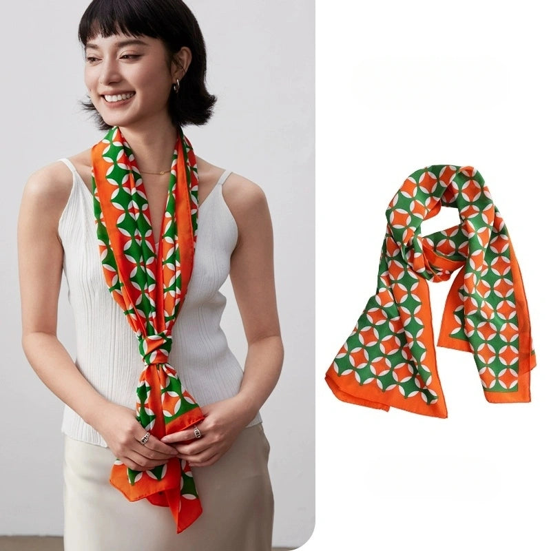 Orange green geometric long silk scarf styled around the neck with matching flat lay detail