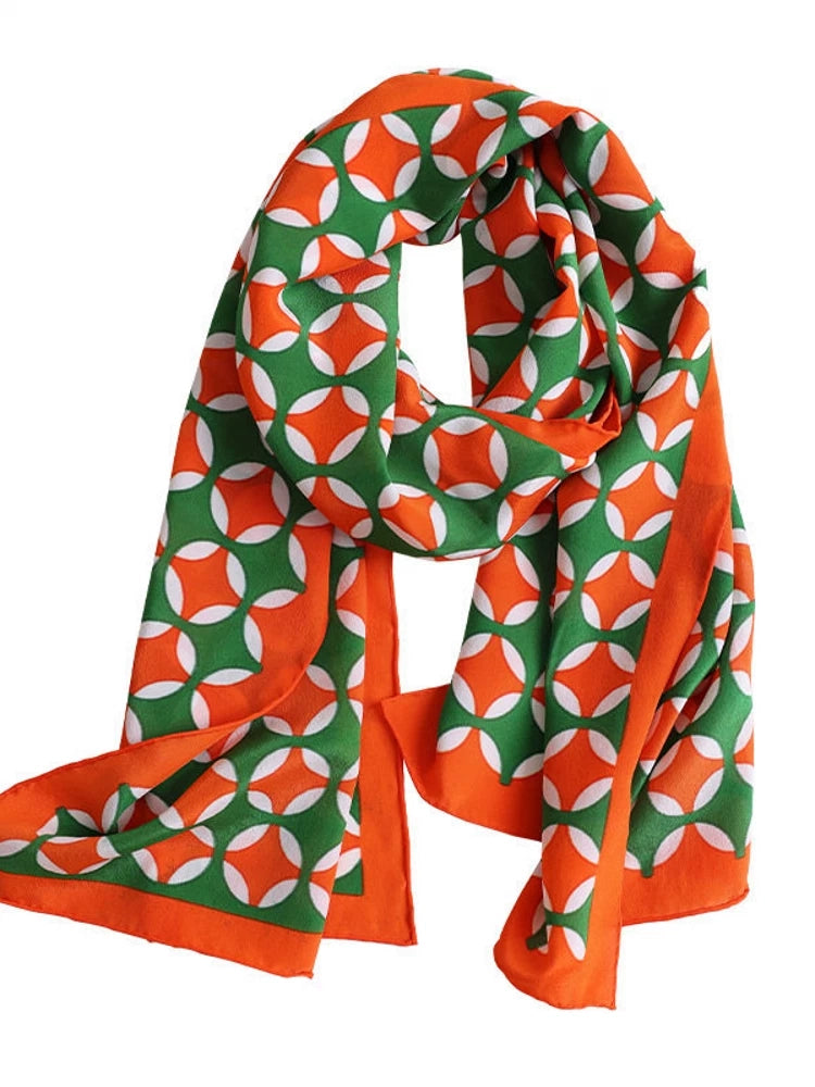 Orange green geometric pattern long silk scarf displayed on white background
