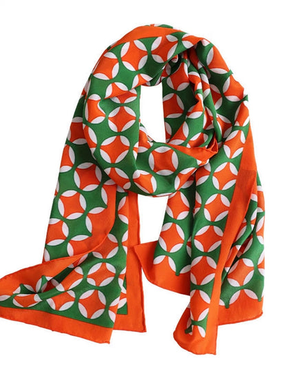 Orange green geometric pattern long silk scarf displayed on white background